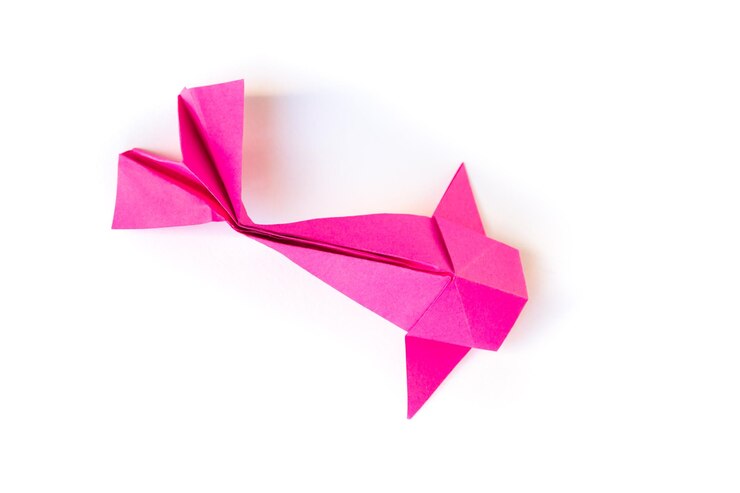 Origami di pesce di carta rosa isolato su sfondo bianco