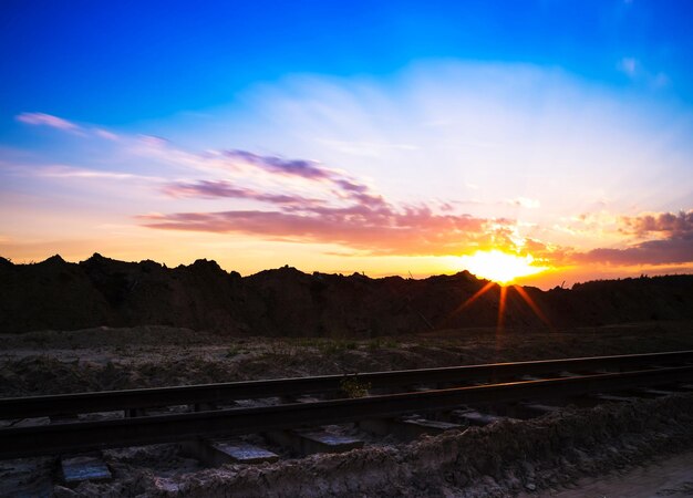 Orizzontale vivido tramonto sullo sfondo del paesaggio della ferrovia della ferrovia d'epoca sullo sfondo