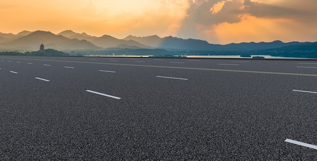 Orizzonte della pavimentazione della superstrada e delle nuvole brucianti del cielo