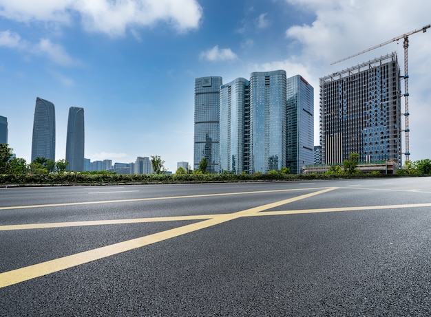 Orizzonte panoramico e strada asfaltata vuota con edifici moderni