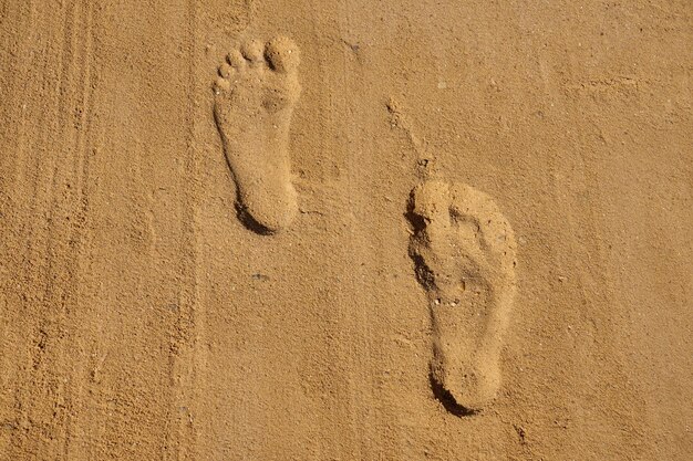 Orme di un uomo sulla sabbia sulla spiaggia