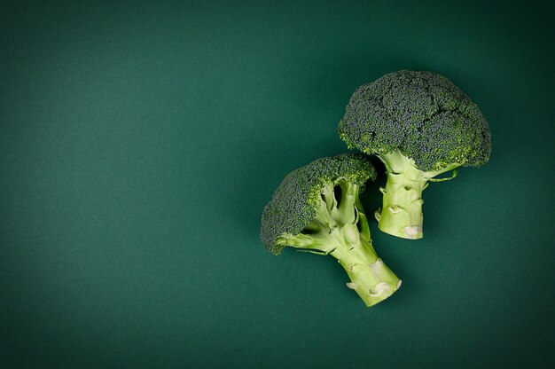 Ornamenti di broccoli crudi organici verdi sani sul tavolo verde