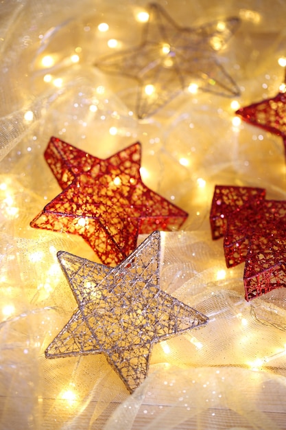 Ornamenti e ghirlanda di Natale sul primo piano luminoso del fondo
