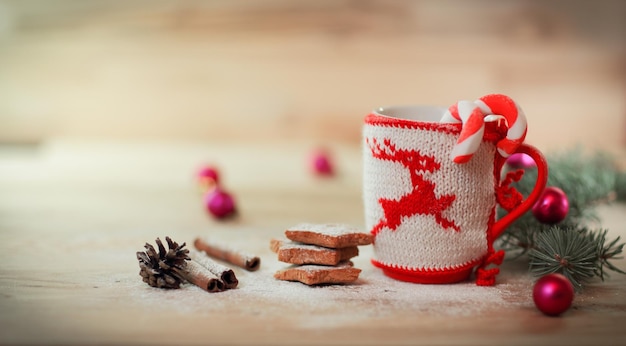 Ornamento della tazza di Natale e dolci fatti in casa su un tavolo di legno