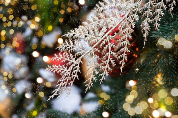 Ornamento di Natale con ramo dorato Estratto di fiocchi di neve e luce decorativa bokeh