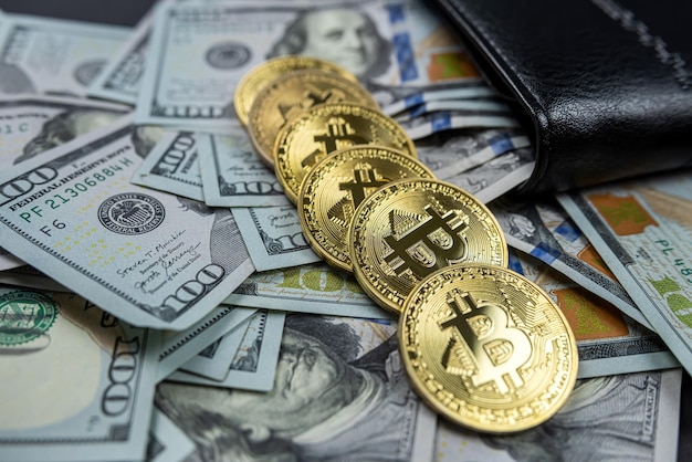 Oro bitcoin e banconote da cento dollari in un portafoglio in pelle