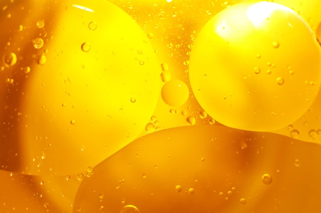 Oro Bolle di olio vicino cerchi di acqua arancione macro astratto sfondo giallo lucido