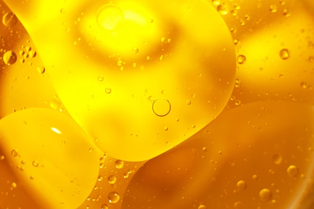 Oro Bolle di olio vicino cerchi di acqua arancione macro astratto sfondo giallo lucido