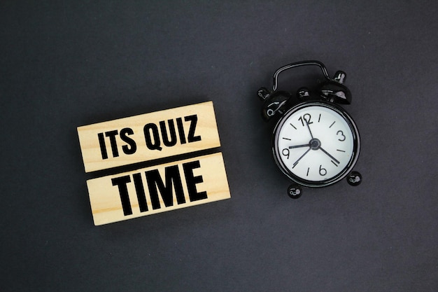 orologio a campana e bastone con le parole It's Quiz Time il concetto di rispondere a quiz o giochi a quiz