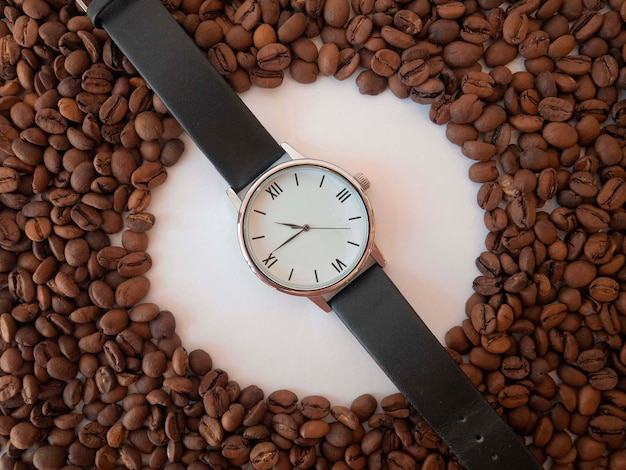 Orologio a mano e caffè sparso macinato