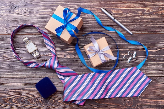 Orologio, cravatta, penna su legno. Confezioni regalo e gemelli. Regali per l'uomo alla moda.
