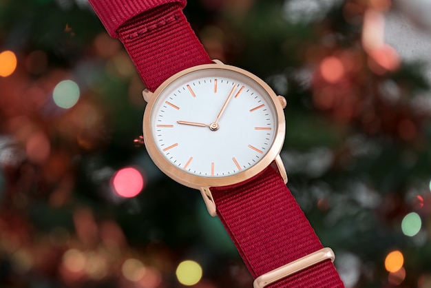 Orologio da polso con cinturino in nylon rosso davanti alle luci di Natale