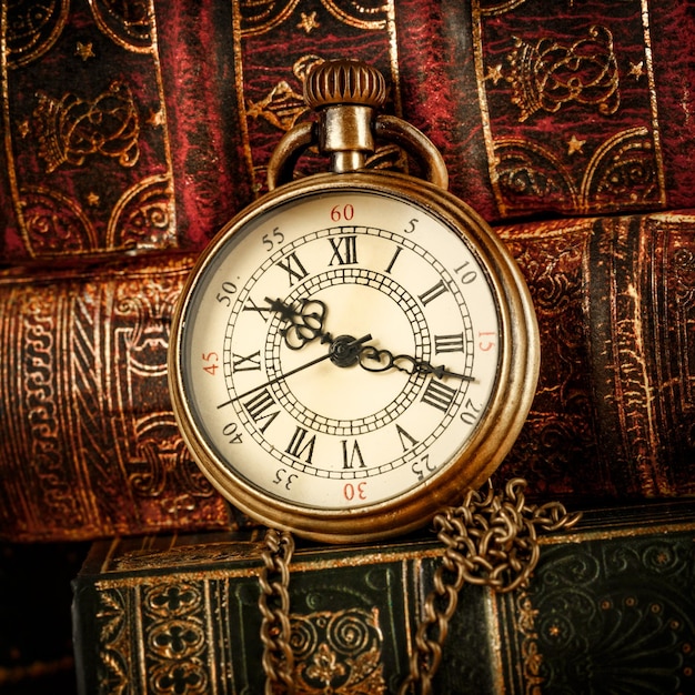 Orologio da tasca antico d'epoca sullo sfondo di vecchi libri