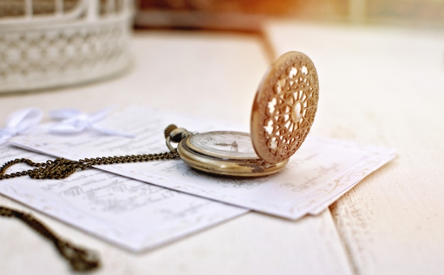 Orologio da tasca aperto vintage e lettera antica. Natura morta retrò.