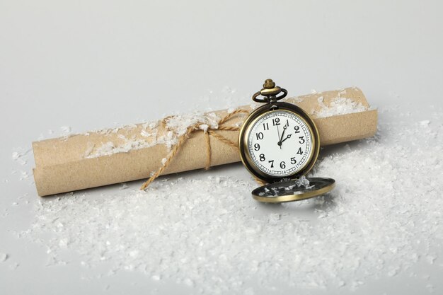 Orologio da tasca con neve su sfondo chiaro