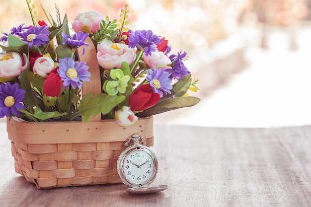 orologio da tasca e fiori in cestino