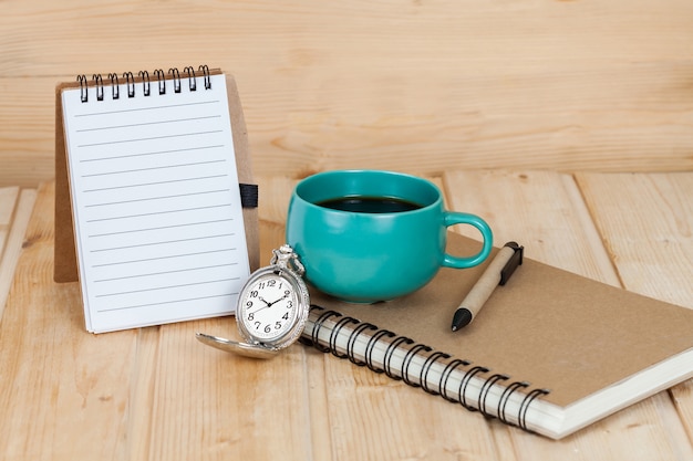 orologio da tasca e tazza di caffè sul libro.