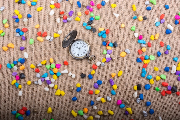 Orologio da tasca tra ciottoli colorati