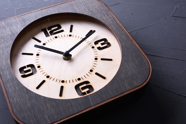 Orologio di legno fatto a mano sul tavolo di legno. Avvicinamento.