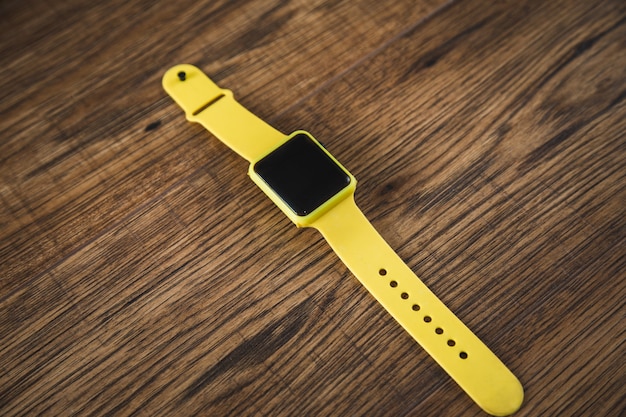 Orologio intelligente giallo sul tavolo di legno
