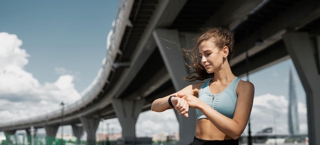 Orologio intelligente sul braccio per allenare una donna sportiva che fa esercizi di fitness per strada