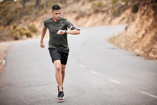 Orologio intelligente uomo e corsa su strada per esercizi di allenamento cardio e maratona in natura Cronometro corridore sportivo e atleta controlla il tempo della frequenza cardiaca o monitora i progressi del corpo degli obiettivi di salute