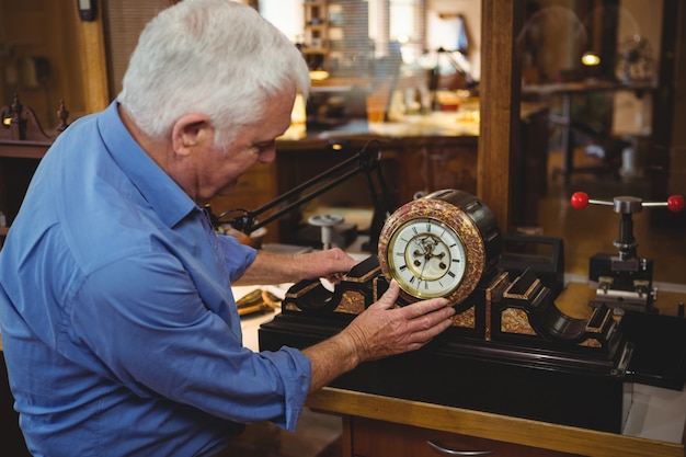 Orologista che controlla un orologio in officina