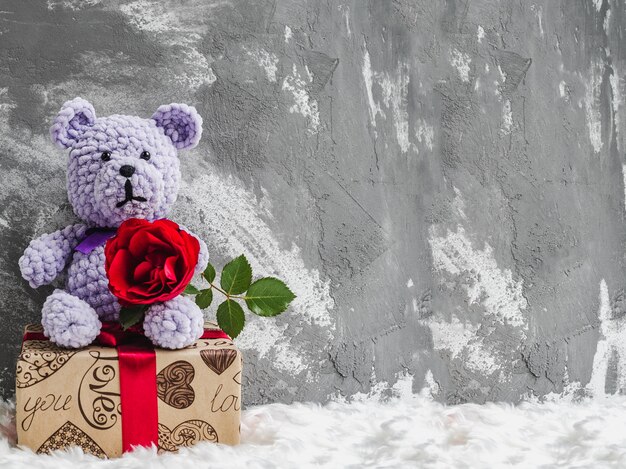 orsacchiotto con una rosa rossa su una confezione regalo