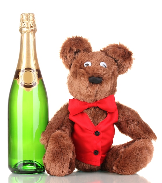 Orso giocattolo e bottiglia di champagne isolati su bianco