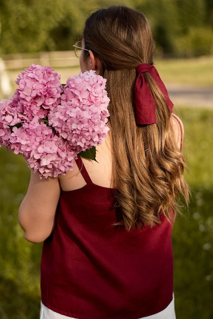 ortensia rosa. la ragazza tiene un mazzo di ortensie. ragazza con fiori