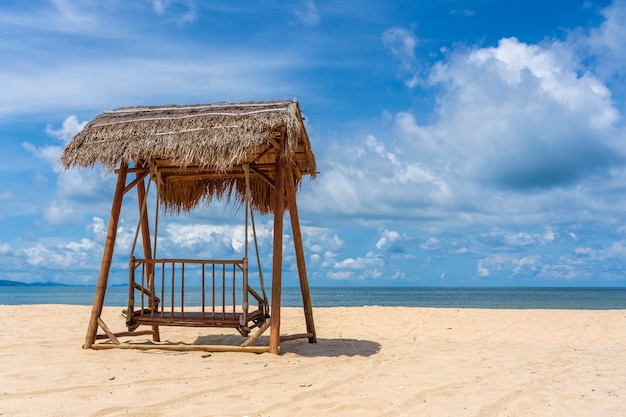 Oscillazione di legno sotto un tetto ricoperto di paglia su una spiaggia tropicale sabbiosa vicino al mare sull'isola di Phu Quoc, Vietnam. Concetto di viaggio e natura