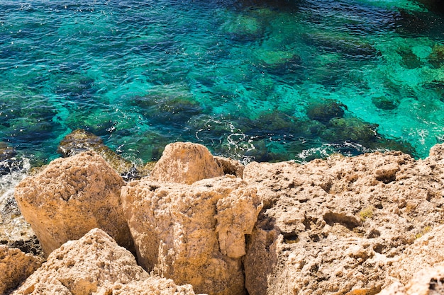 Oscilli le scogliere e la baia del mare con acqua azzurrata vicino a Protaras, isola della Cipro.