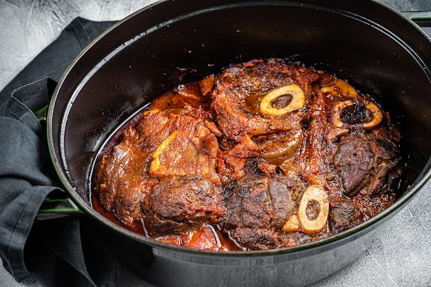 Osso buco stinco di vitello tagliato a croce brasato con pomodori e spezie carne di manzo Ossobuco Sfondo bianco Vista dall'alto