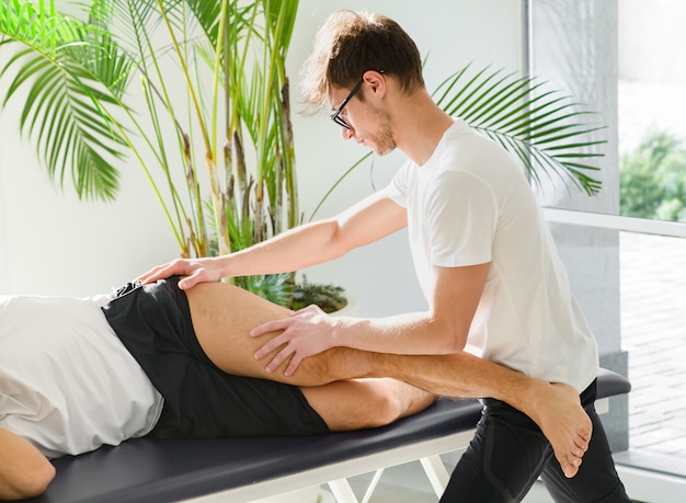 Osteopata che esegue un trattamento tensore della fascia lata