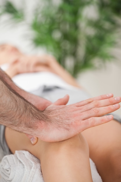 Osteopata usando il palmo della mano per massaggiare un ginocchio