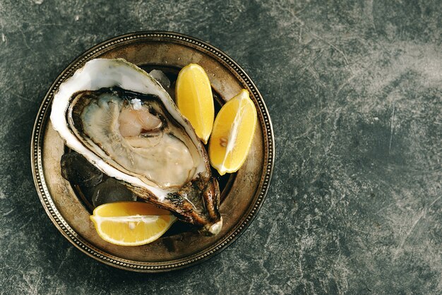 Ostriche crude fresche giganti in un guscio con limone su ghiaccio