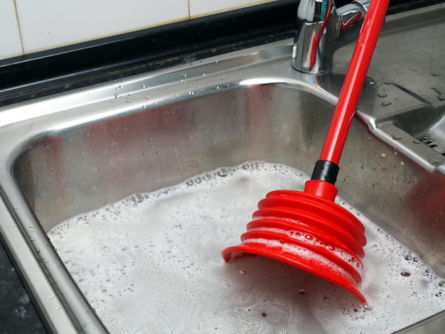 Ostruzione del tubo dello stantuffo rosso dell'acqua del rubinetto del lavello in acciaio inossidabile