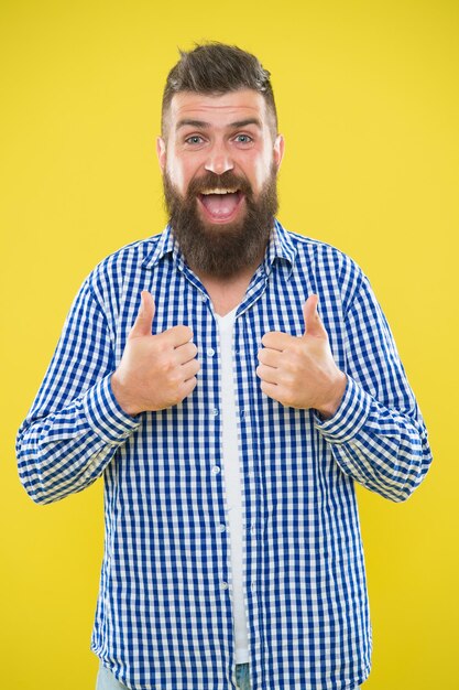 Ottimo lavoro. Barba moda e concetto di barbiere. Uomo barbuto hipster elegante barba sfondo giallo. I consigli del barbiere mantengono la barba. Cura elegante di barba e baffi. Aspetto hipster. Espressione emotiva.