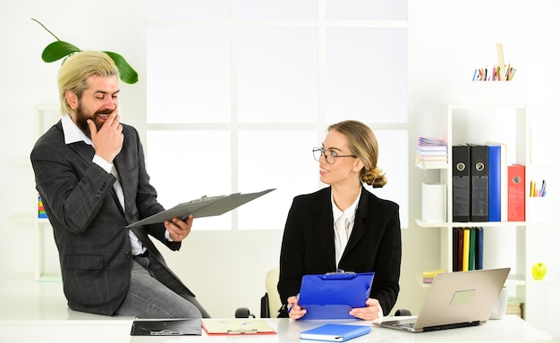 Ottimo lavoro uomo d'affari e assistente segretario guarda documentazione capo e dipendente collaborazione di successo uomo e donna brainstorming in collaborazione in ufficio e concetto di team building