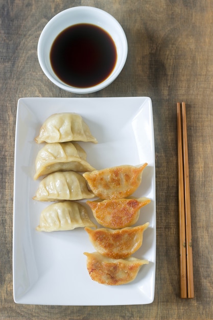 Otto jiaozi o gedza bolliti o fritti serviti con salsa di soia.