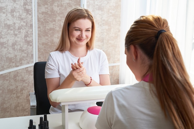 Oung donna che fa manicure in salone. Concetto di bellezza.