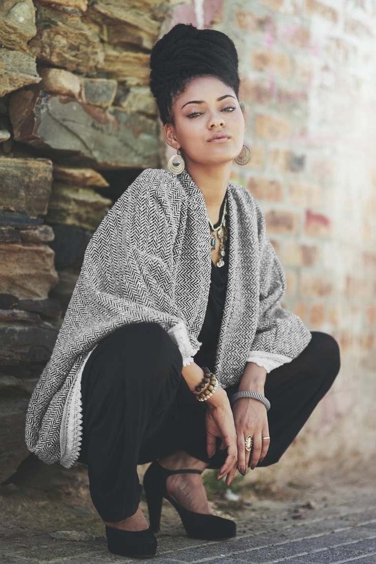 Photo outdoor serious and portrait of woman with style for trendy fashion accessories and makeup high heels braids and female person with confidence by brick wall for jewellery clothes and cosmetics