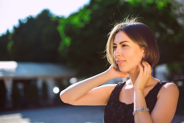 Outdoot ritratto di splendida modella bruna che indossa abiti alla moda, in posa per le strade della città. Spazio per il testo