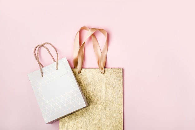 Pacchetti bianchi e oro su sfondo rosa. Concetto di vendita di vacanze in colori pastello.