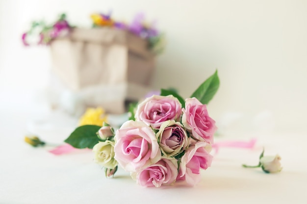 Pacchetto di bouquet di rose fresche con fiori su sfondo chiaro concetto romantico