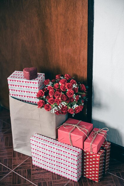 pacchi per le feste san valentino piacevoli sorprese scatola regalo e rosa dietro la porta