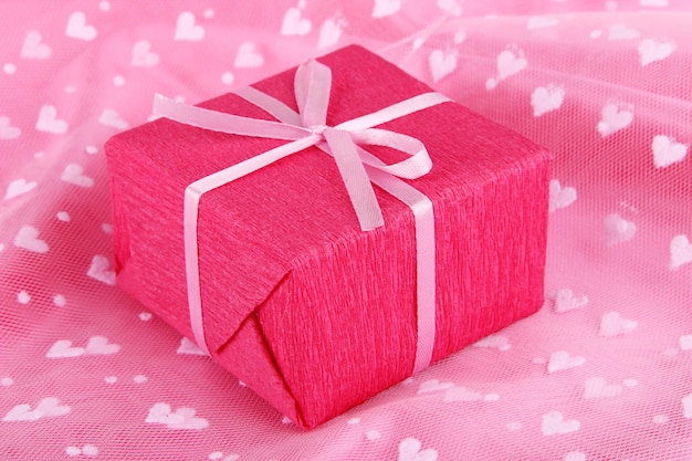 Pacco romantico su sfondo di stoffa rosa