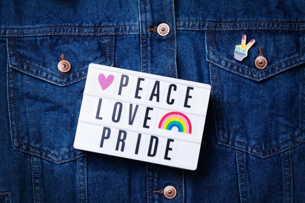 Pace amore orgoglio testo bandiera lgbtq arcobaleno su sfondo denim