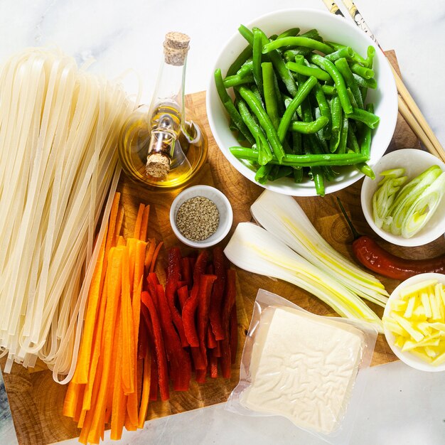 Pad Thai ingredienti su un tagliere su un tavolo di marmo bianco