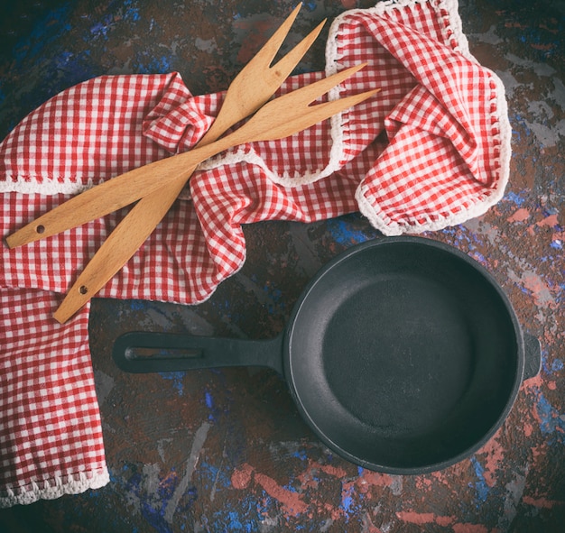 Padella in ghisa nera con manico e due forchette in legno